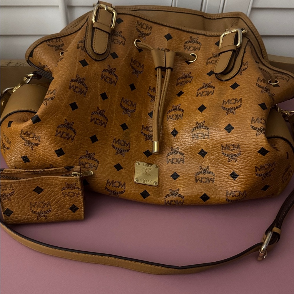MCM Cognac Visetos Drawstring Shoulder Bag with Crossbody Strap and coin pouch.